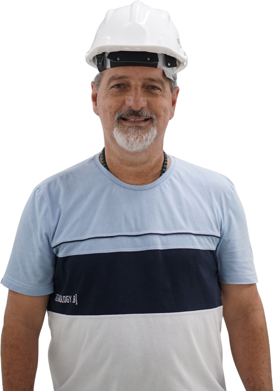 Joa de capacete branco e camisa azul, sorrindo de frente para a câmera
